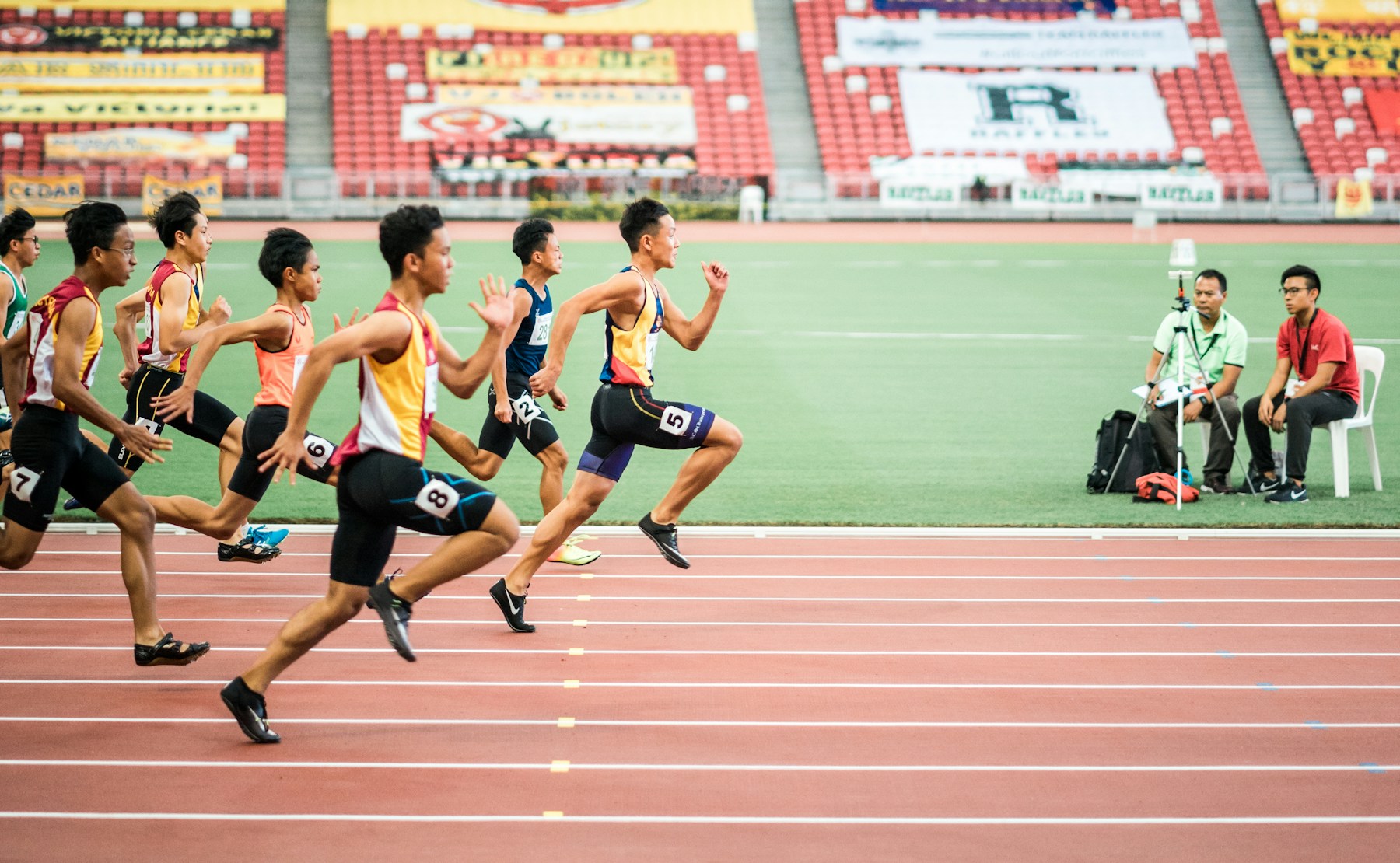 陸上競技場のトラックを走る選手たちを横から見た場面